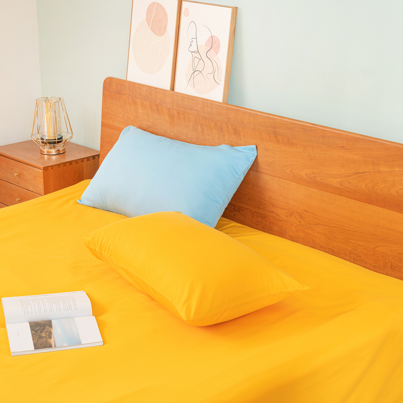 one blue pillowcase, one orange pillowcase and an orange flat sheet