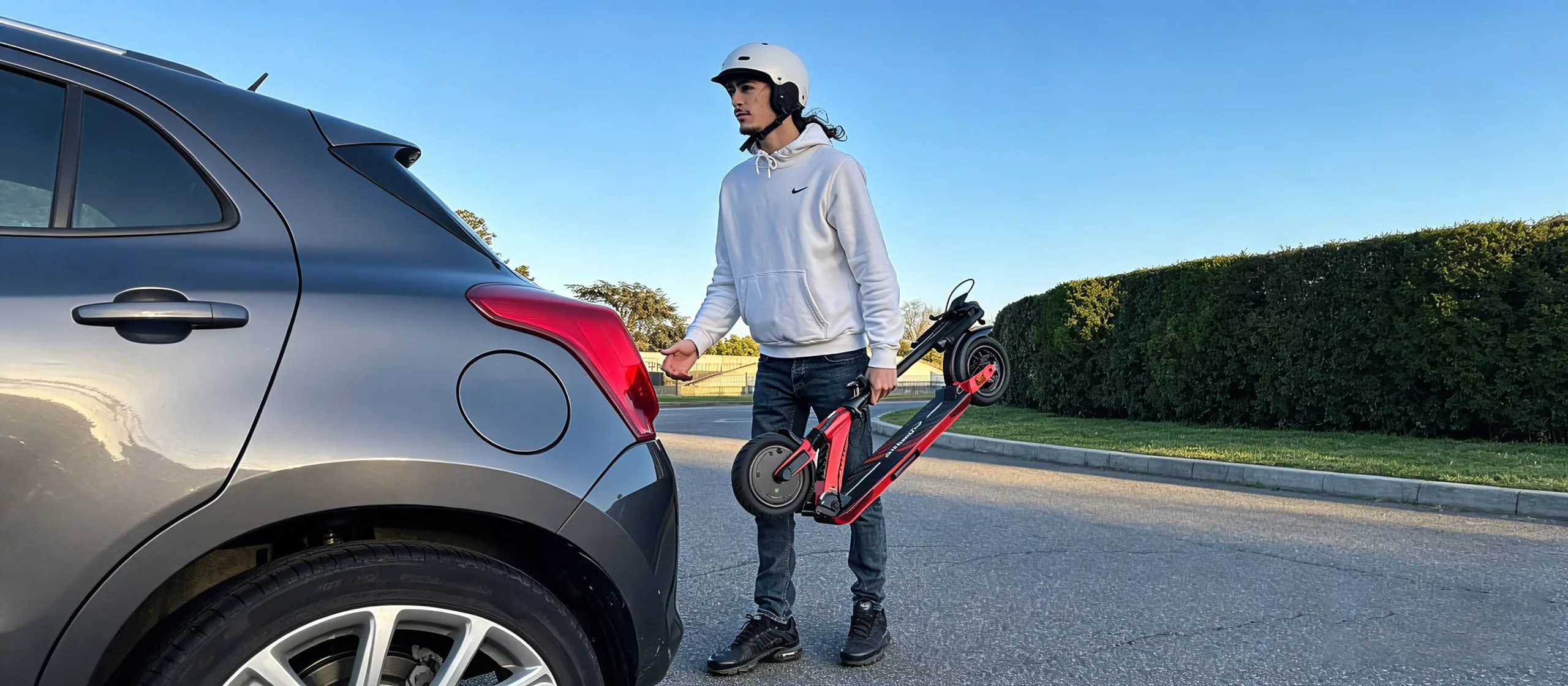 Rider carrying a folded Butterfly Ultra beside a car
