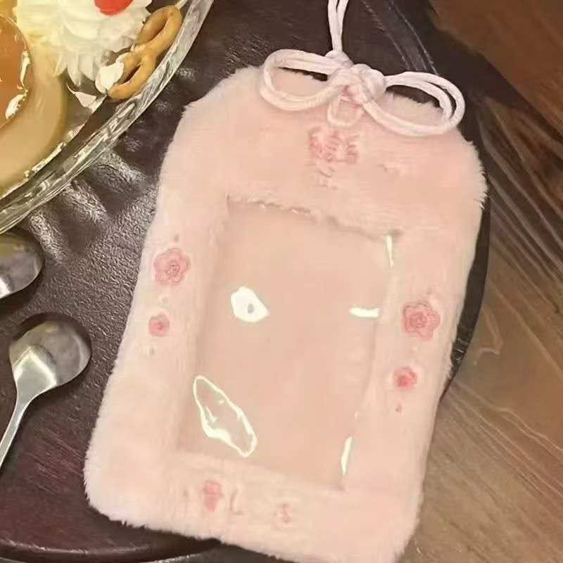 Pastel pink plush card holder with rose embroidery and a bow design for a soft aesthetic.