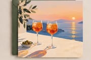 Mediterranean sunset greeting card with two drinks and a coastal view