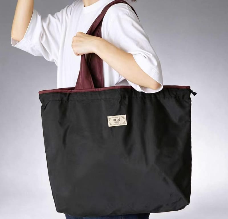 Burgundy-colored shoulder strap, black foldable shopping bag