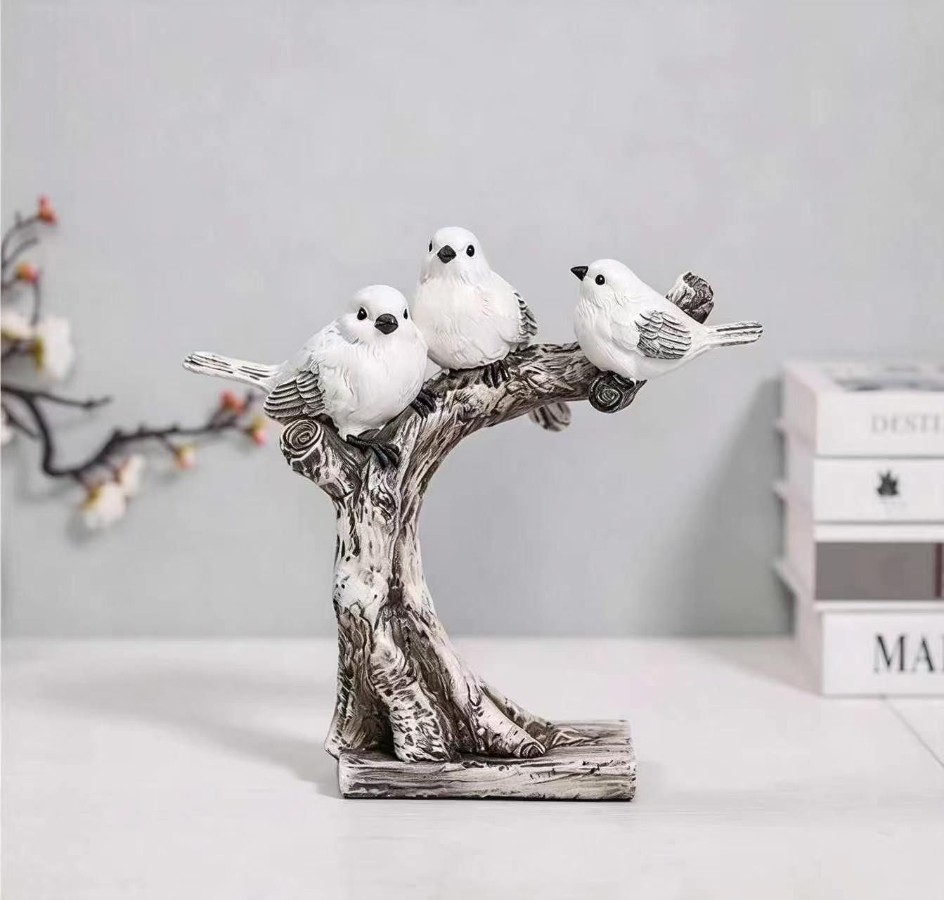 Three white birds perched on a textured tree sculpture